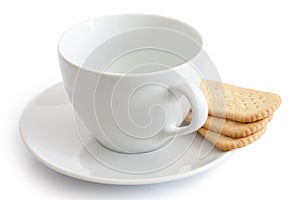 Empty white ceramic cup and saucer with finger tea biscuits. Iso