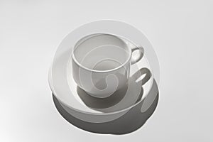 Empty white coffee cup. hard shadows on gray background