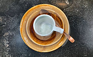 empty white coffee or tea cup on a brown saucer on dark table background
