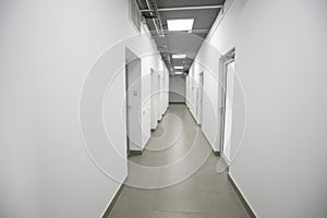 Empty white corridor with closed doors