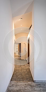 Empty white corridor with spotlight and tile