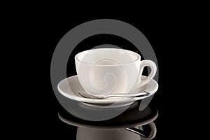 Empty white cup for coffee or tea on a dark background with reflection