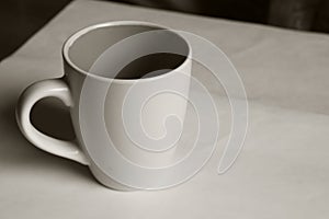 Empty white cup on a light background. Cup with place for text. Copyspace