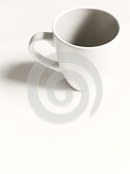 Empty white cup on a light background. Cup with place for text. Copyspace