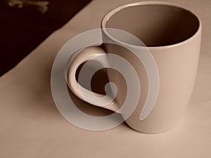 Empty white cup on a light background. Cup with place for text. Copyspace