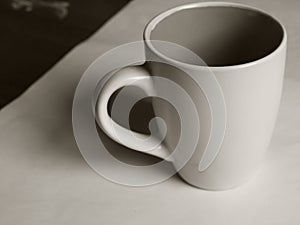 Empty white cup on a light background. Cup with place for text. Copyspace