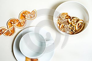 Empty white cup on the white saucer with dried lemon on the side