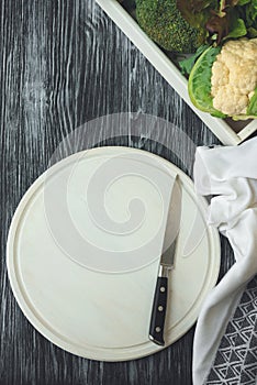 Empty white cutting board with knife on dark rustic Background. Flat Lay. Top view. Mock-up