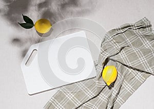 Empty white cutting board ripe lemon lie on the kitchen table, top view flat lay, mockup