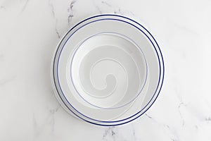 Empty white dinner plate top view on a white background