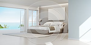 Sea view bedroom of luxury summer beach house with double bed near wooden floor terrace and swimming pool.