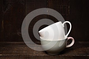 Empty white and gray cup on rastic wooden background. photo