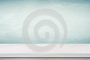 Empty white marble table over green cement wall background