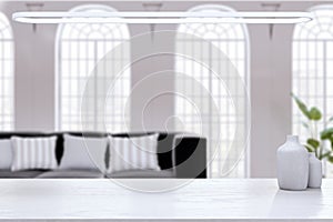 Empty white mock up desk on blurry office interior background with sofa, pillows, decorative plant and window with city view. 3D