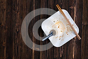 Empty white noodle bowl with spoon and chopsticks after eat on w