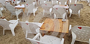 Empty white plastic chairs and wooden tables