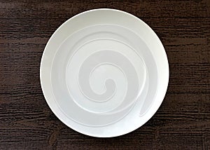 Empty White Plate against a Brown Wood Background