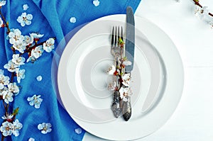 Empty white plate with a fork and knife