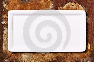 Empty white plate on rusty background