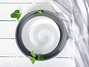 empty white plate on a table, dinner setting, mockup for food styling. tablecloth and cement round tray, top view