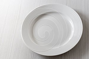 an empty white plate on a white table background