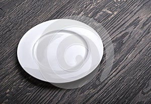 Empty white plate on wooden