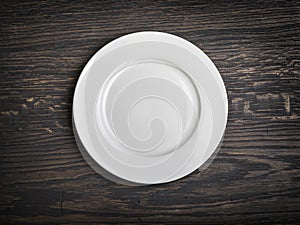 Empty white plate on wooden