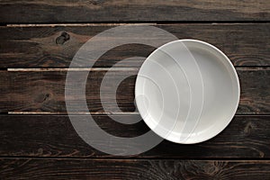 Empty white plate on a wooden loft table