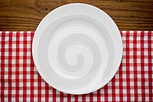 Empty white plate on wooden over red grunge