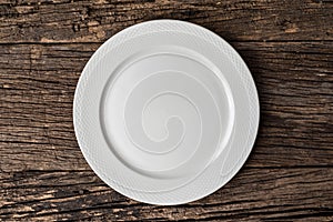 Empty white plate on wooden table