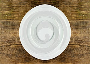 Empty white plate on wooden table