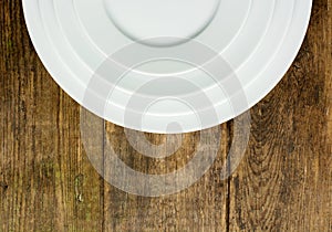 Empty white plate on wooden table