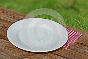 Empty white plate on wooden table
