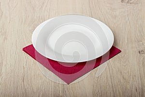 Empty white plate on wooden table