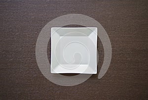Empty white plate on wooden table