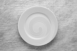 Empty white plate on wooden table
