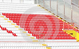 empty white and red seats in the stands of the stadium
