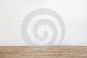 Empty white room with wooden floor and wood trimmed wall photo