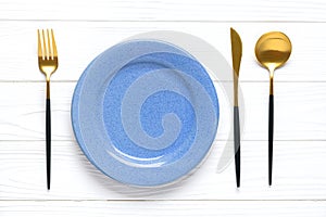 Empty white round blue plate, fork, knife, spoon on wooden table Top view Flat lay Dishes for breakfast, lunch or dinner Mock up