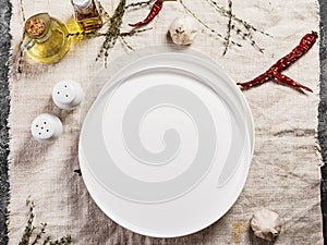 Empty white round plate. Top view. Linen tablecloth. Copy space