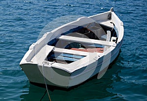Empty White Row Boat on deep blue sea photo