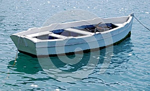 Empty White Row Boat tied to dock