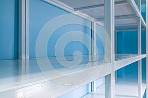 Empty white shelves in blue storage room