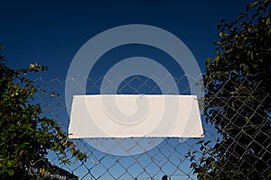 Empty white sign on  fence offers copy space