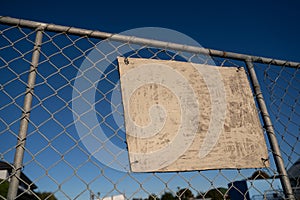 Empty white sign on  fence offers copy space