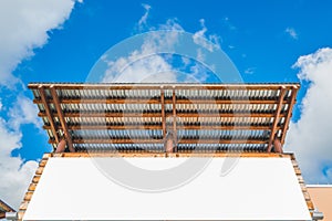 Empty white space bill board with wood and zinc roof with blue sky.ready for product display montage.