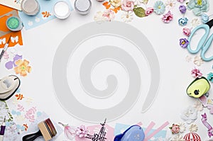 Empty white space in the center surrounded by paper flowers, multi-colored paper and scrapbooking materials photo