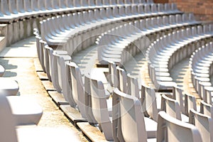 Empty white stadium stand rows with sunlight