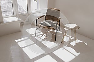 Empty white sunny room with wicker chair and table. Minimalist design