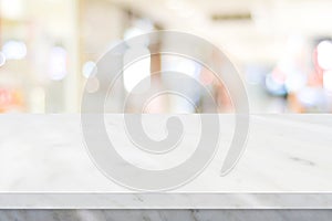 Empty white table top, counter, desk over blur perspective store with bokeh light background, White marble stone table, shelf and photo